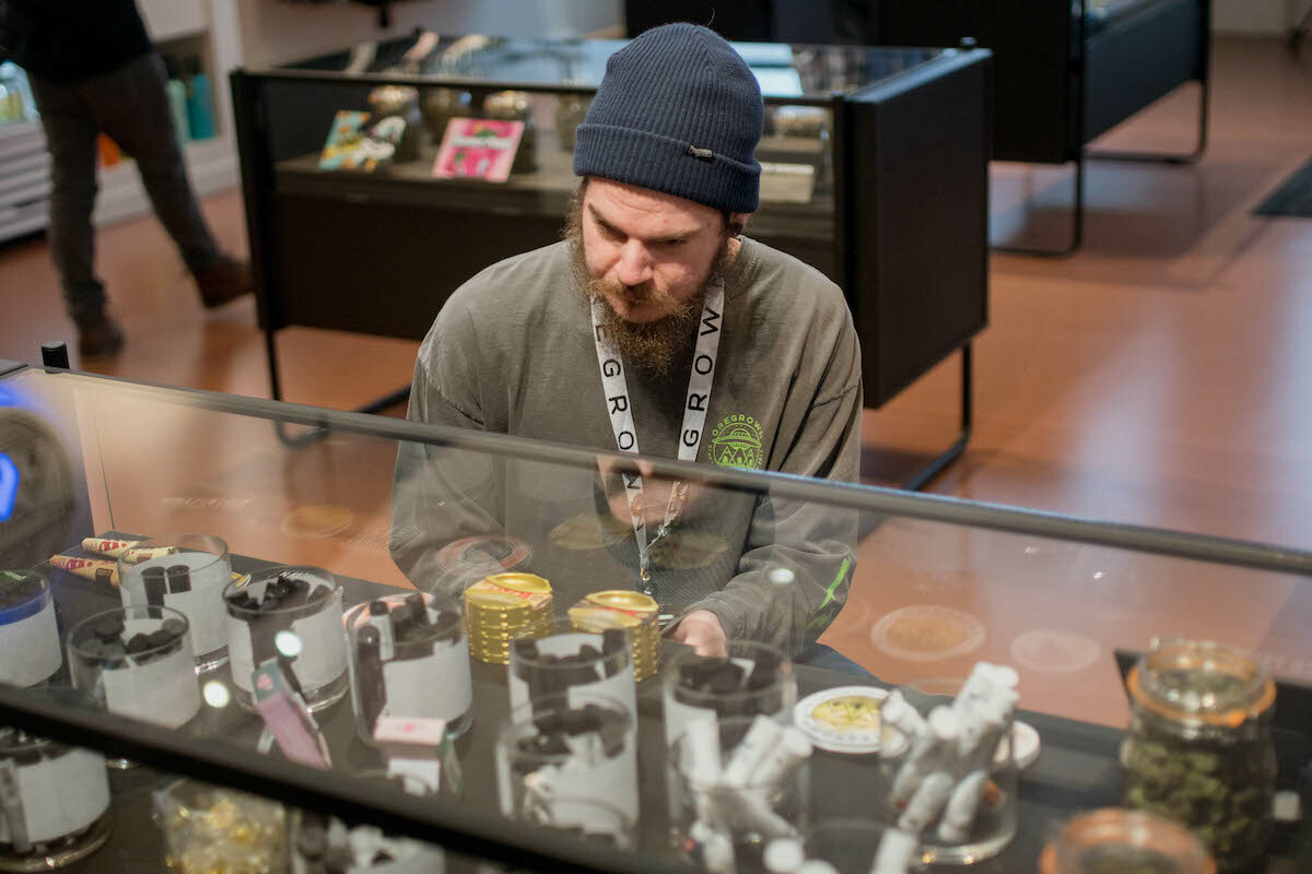 a dispensary employee helps a cannabis consumer